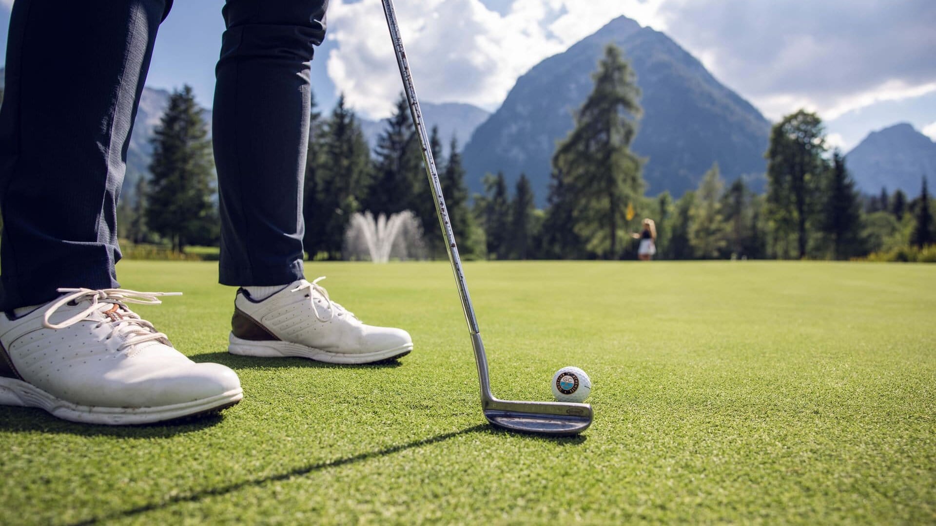 Golfspieler mit Putter auf dem Grün